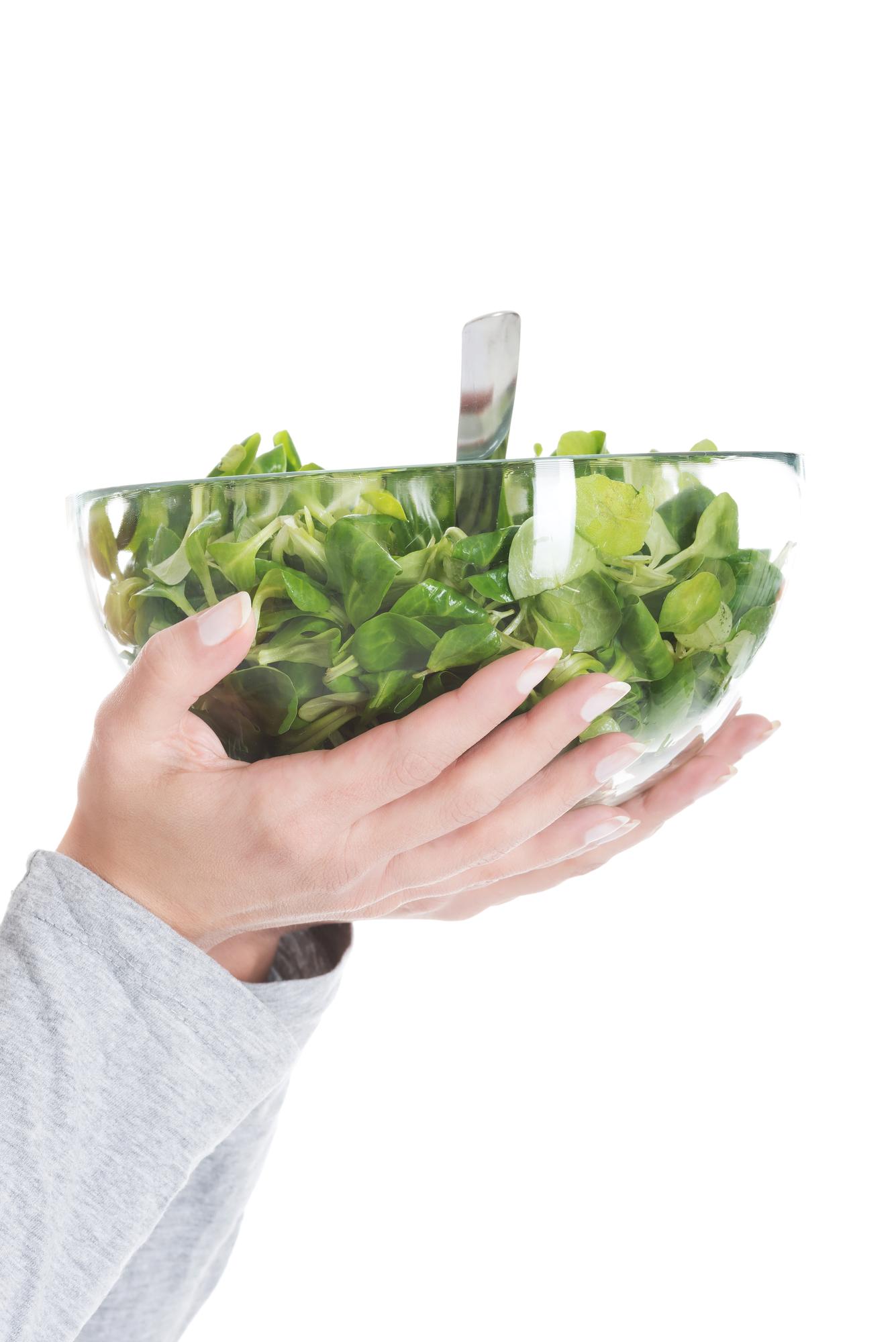 Hands assembling a composed salad with care