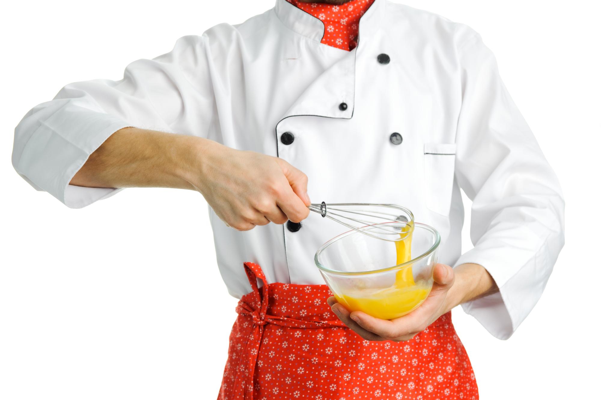 Chef prepping a composed plate with herbs and sauces